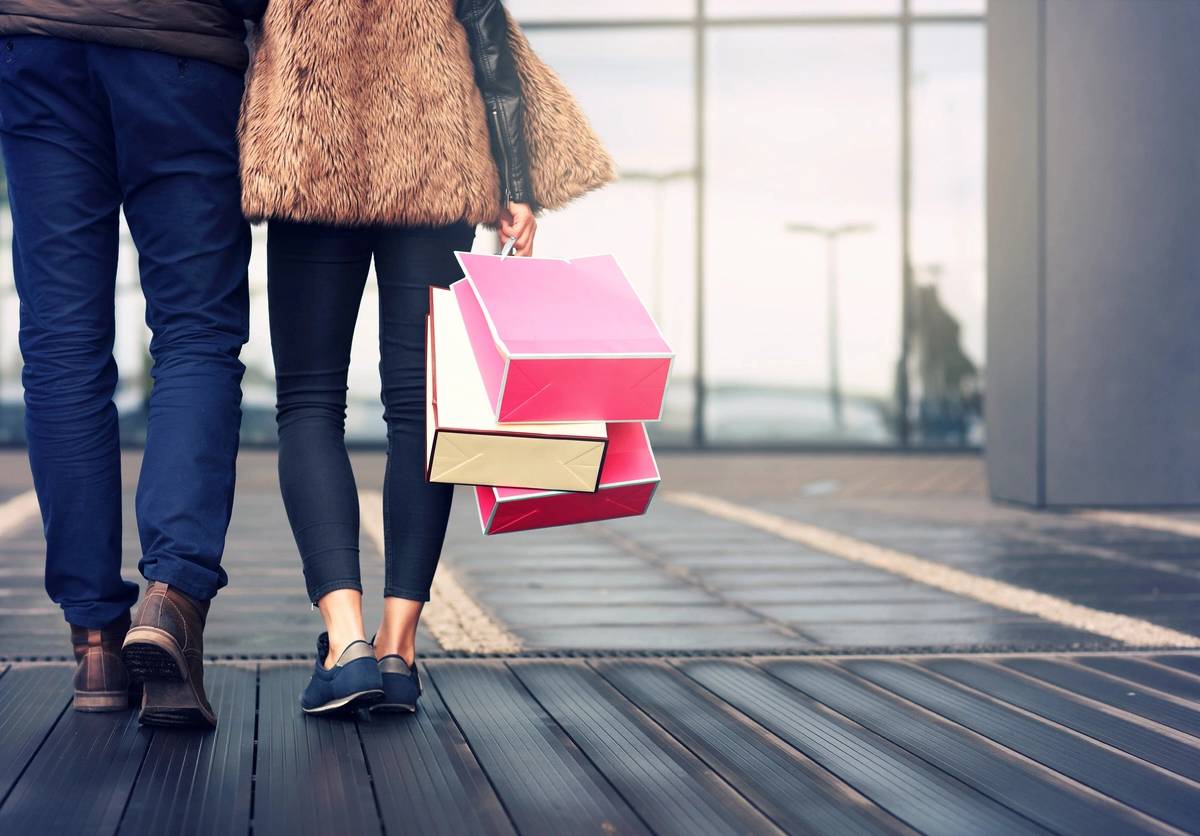 Midsection of couple with shopping bags in city